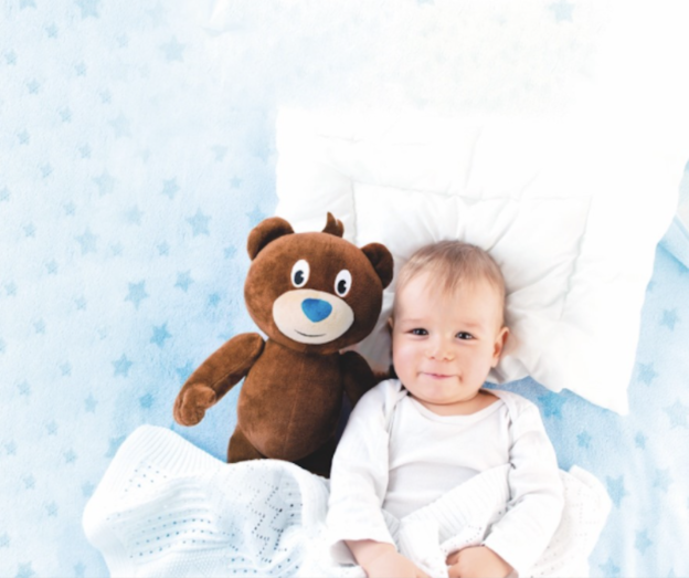bébé au lit avec un ours