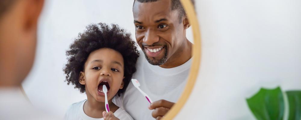 l'enfant se brosse les dents avec son père